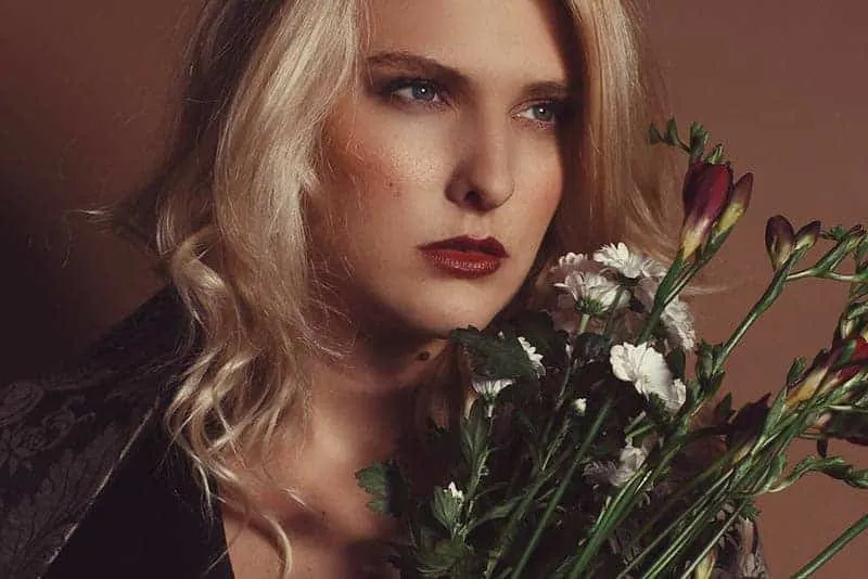 blonde woman holding flowers