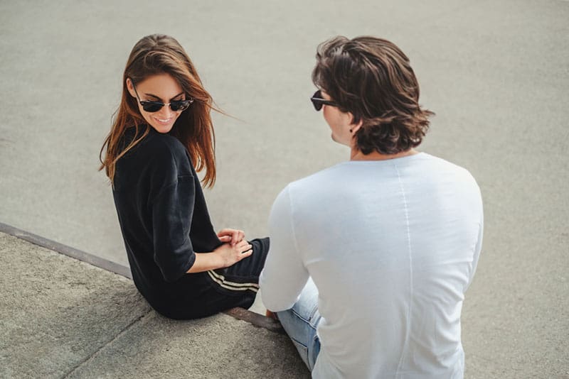 couple wearing sunglasses flirting