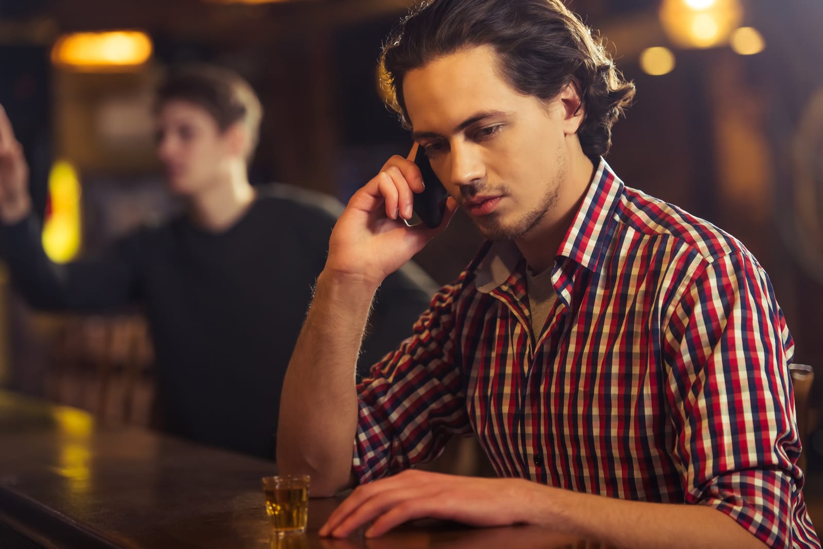 uomo ubriaco al bar che parla al telefono