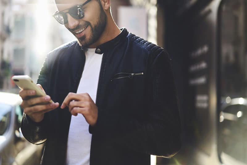 uomo affascinante che guarda il telefono