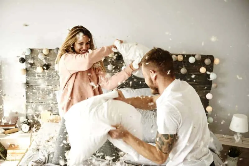 happy couple having a pillow fight