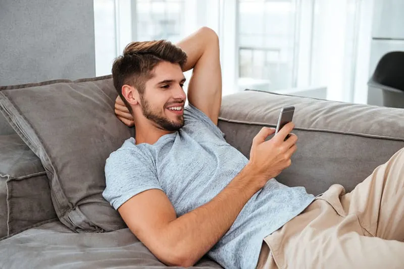 happy man looking at mobile phone