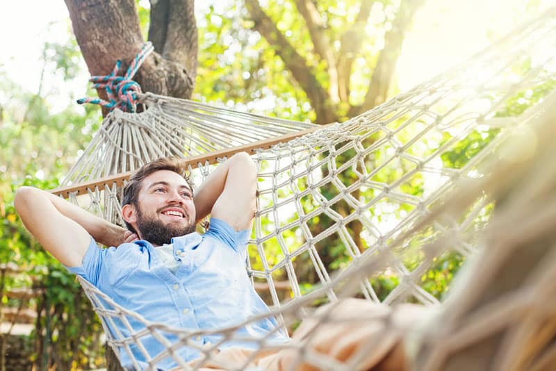 hombre feliz columpiándose en una hamaca