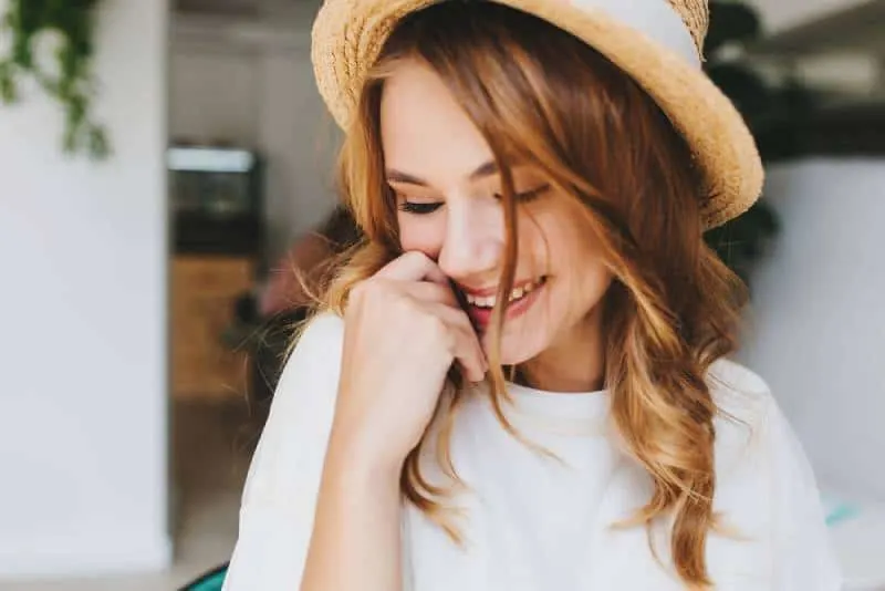 happy shy girl cover face with hand