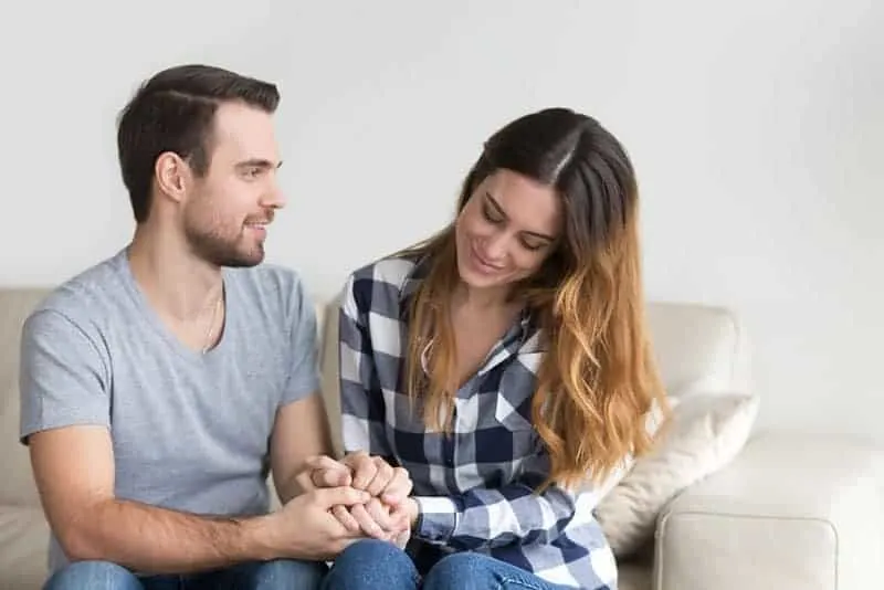 lovely couple holds hands at home