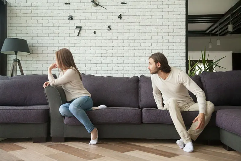 man blaming woman and arguing on the couch