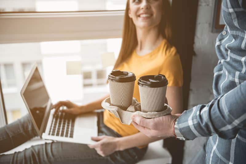 man brings coffee to woman