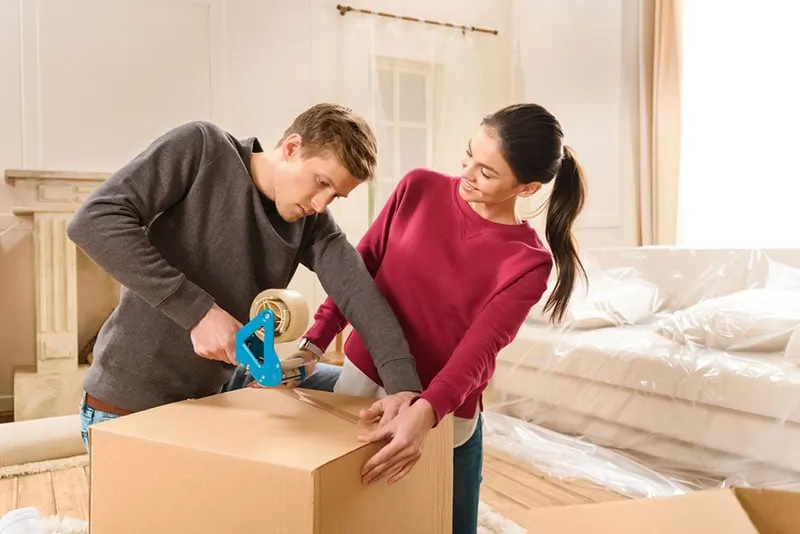 man helping woman to pack box