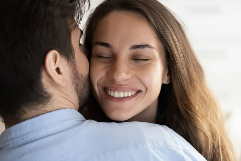 man kissing smiling woman