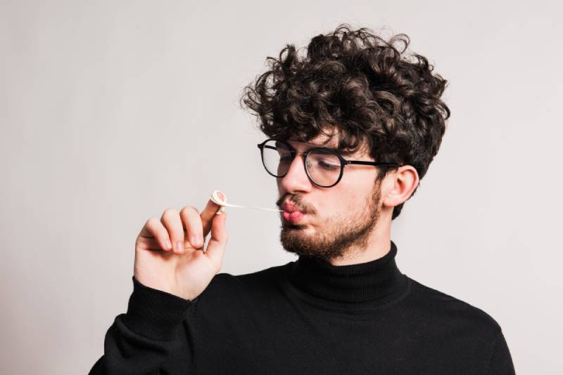 man pulling out chewing gum in a studio