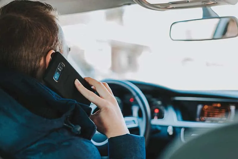man speaking on his phone while driving car