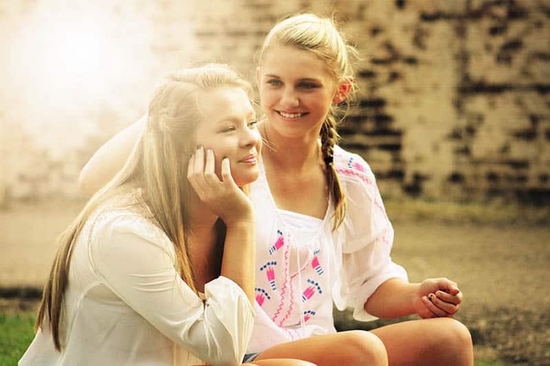 Girl fixing her friends hair 