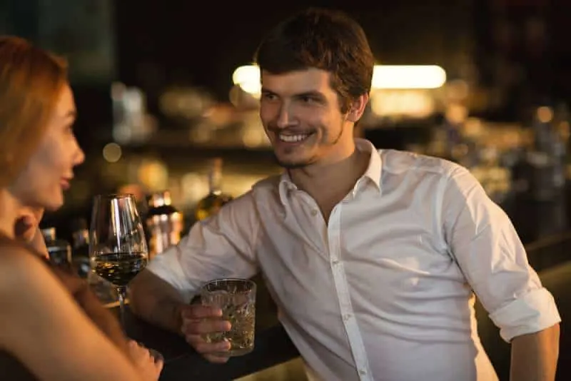 seductively woman at the bar with smiling man