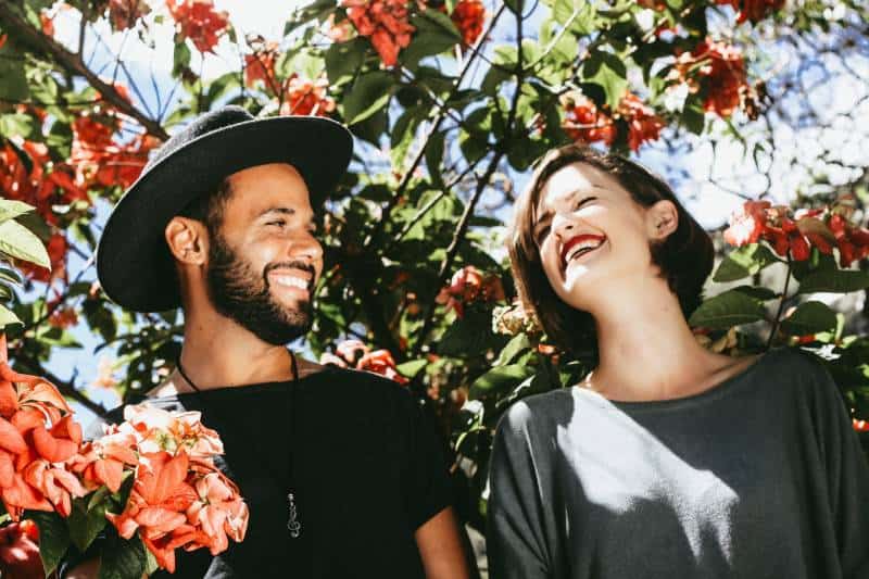 coppia sorridente circondata dai fiori