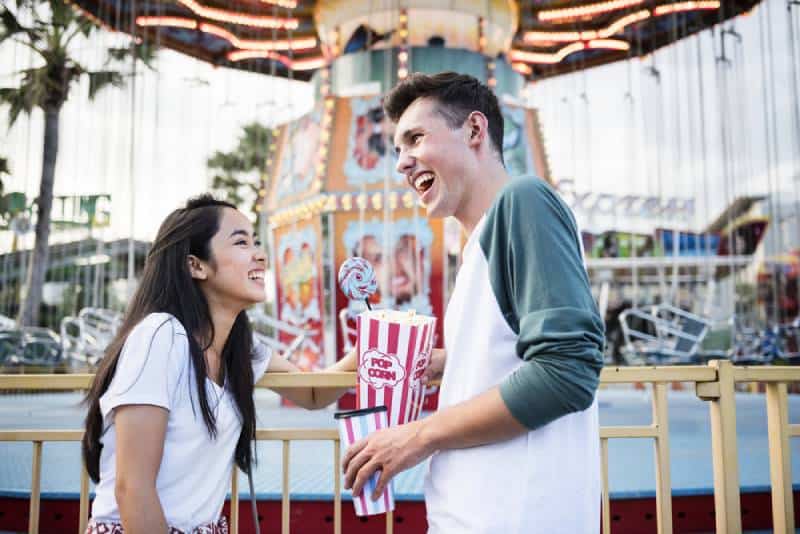 pareja sonriente hablando en carneval