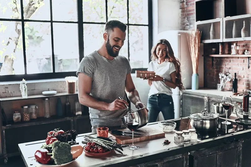 smiling man cooking with woman
