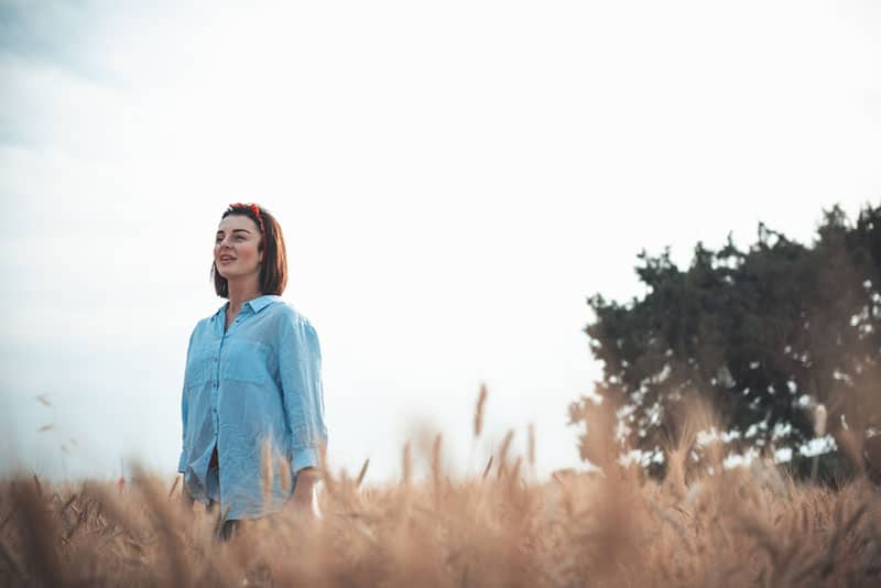 donna sorridente in piedi nel campo