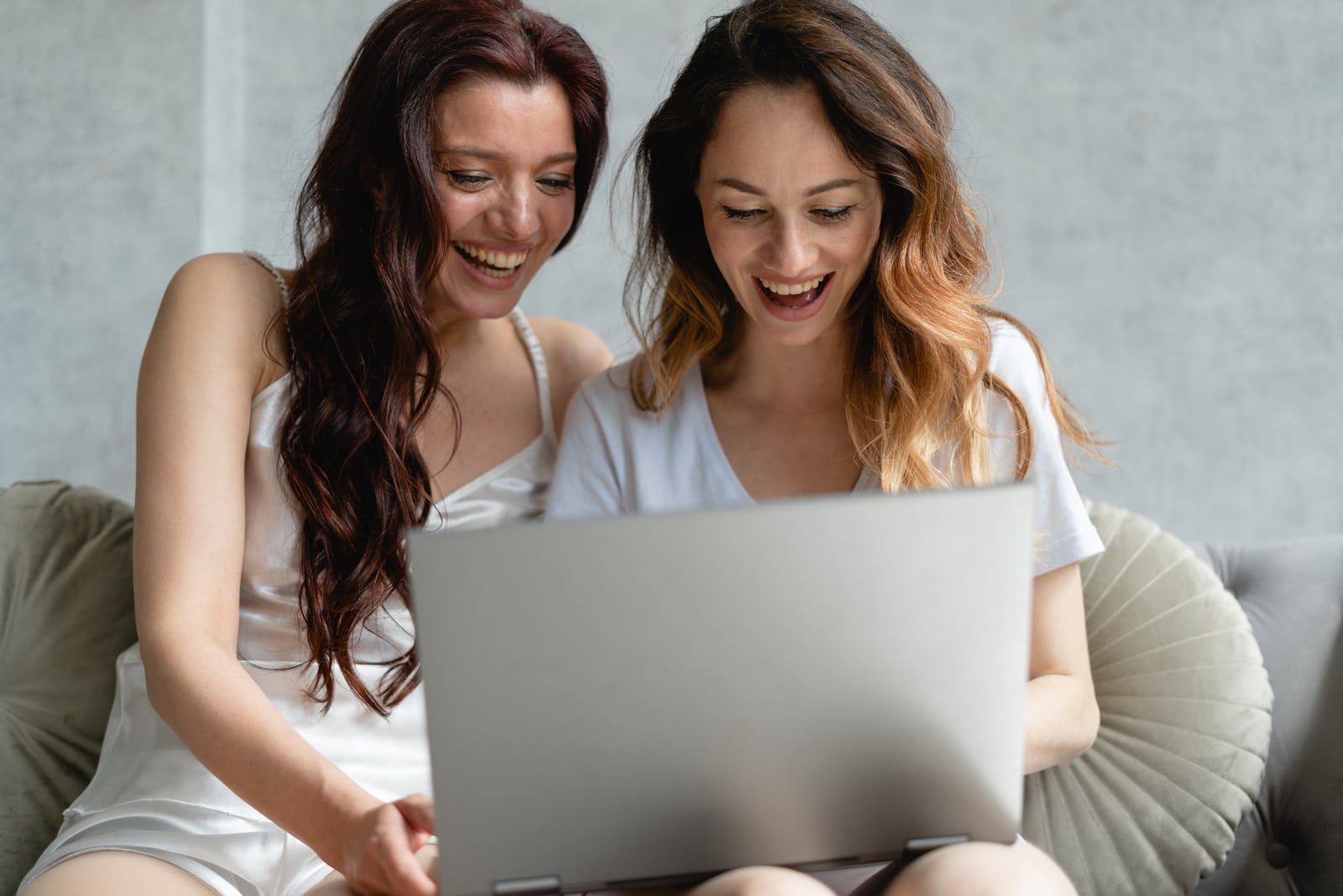 two friends having fun on a laptop