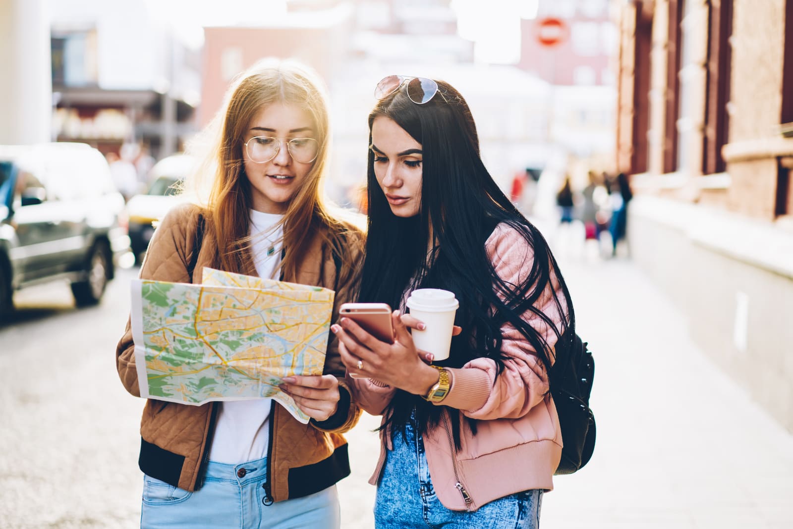 two friends on the street looking at a map