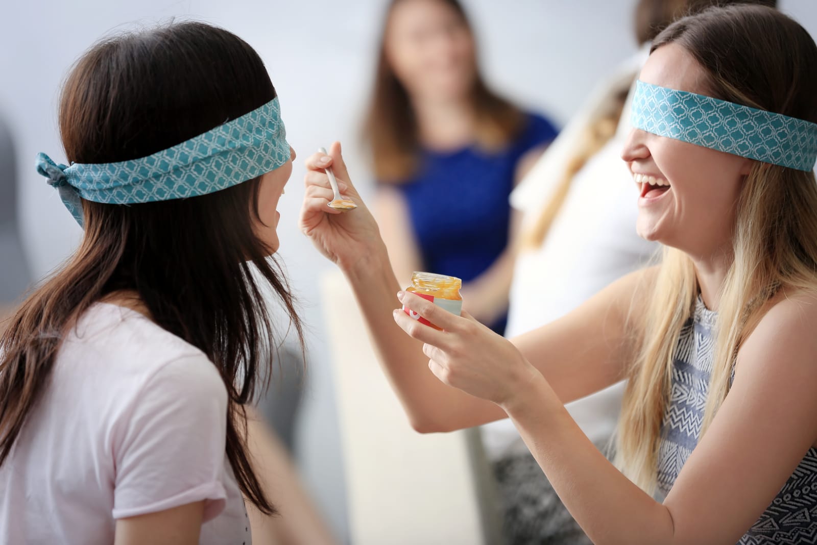 two women taste food blindfolded