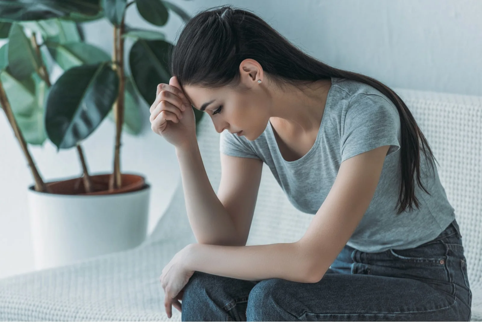 woman sitting on couch looking down