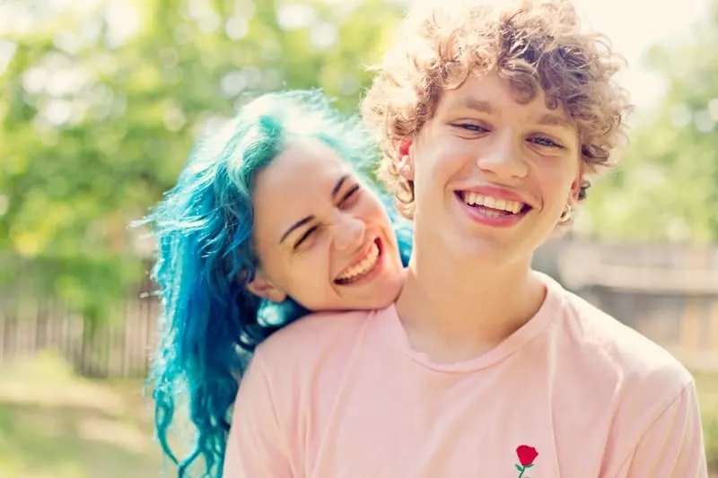 woman with blue hair smiling with her boyfriend