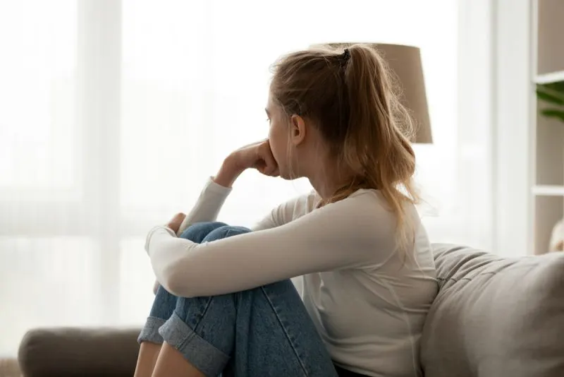 young sad woman sitting on the couch