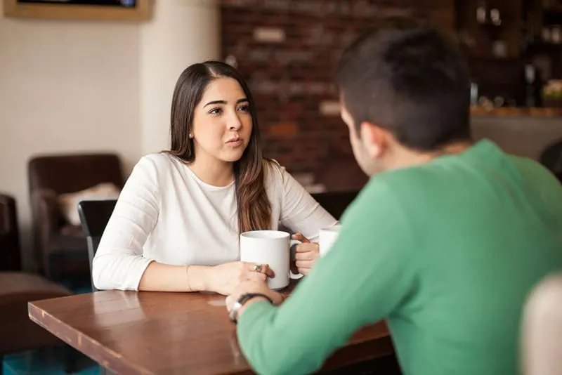 young woman looking at man while talking