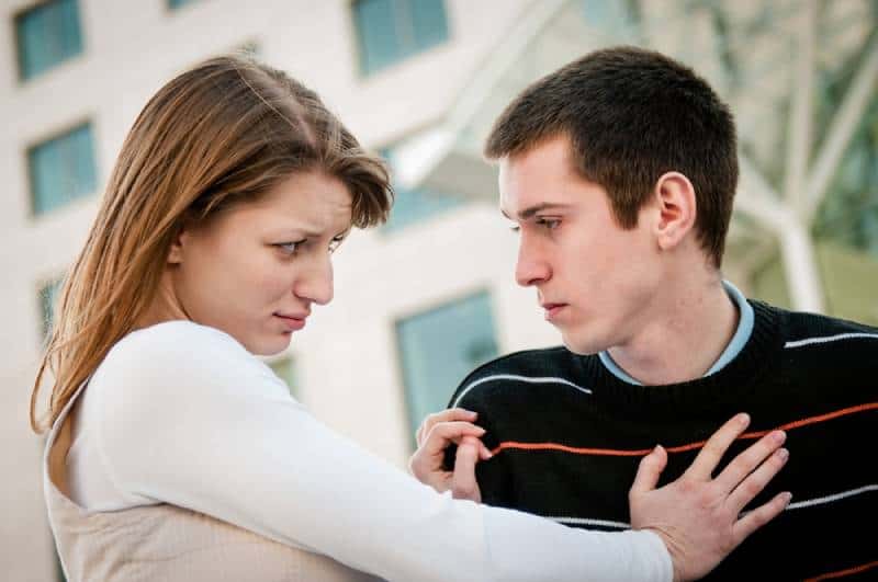 young woman refusing a man outside on the street having relationship problems