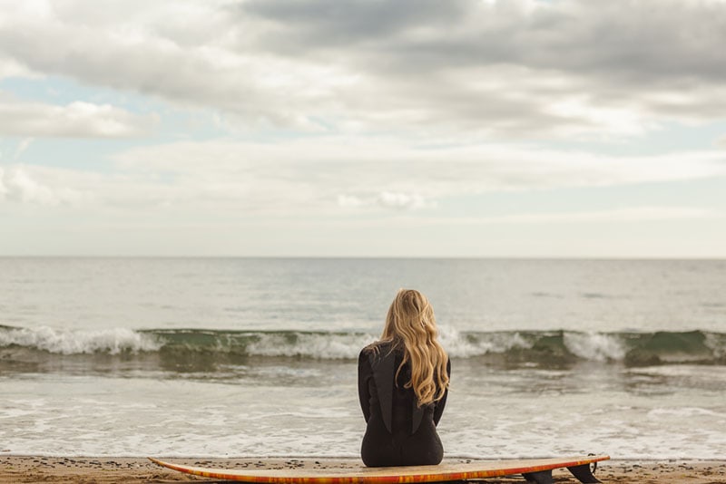 giovane donna seduta sulla spiaggia