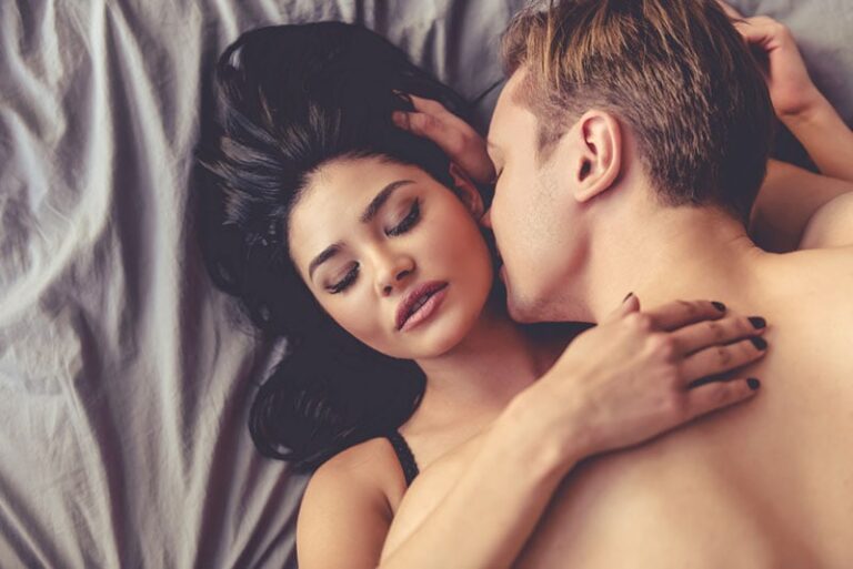 man kissing woman's neck