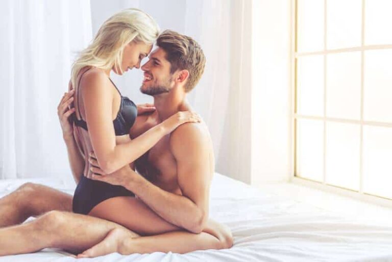 Belo casal apaixonado sentado na cama