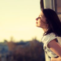 a short-haired woman enjoys the sun on the terrace