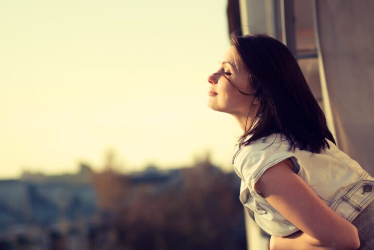 a short-haired woman enjoys the sun on the terrace