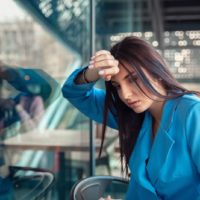 unhappy young woman with head on window