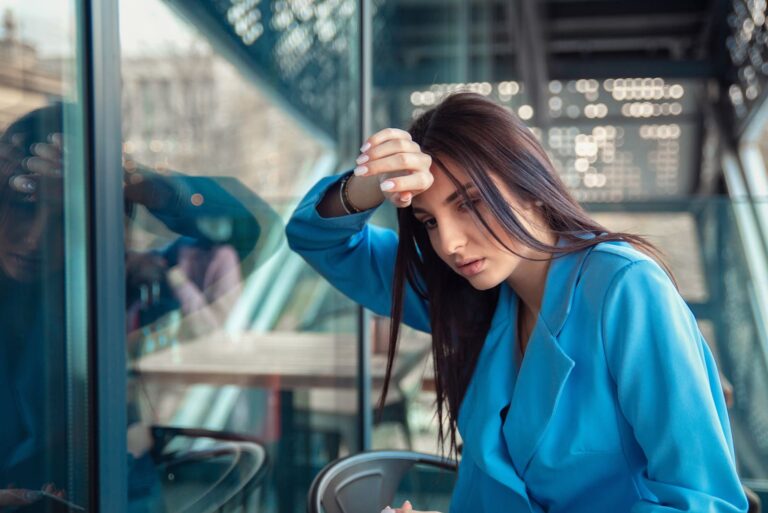 unhappy young woman with head on window