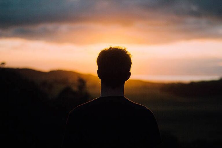 silhouette di uomo di fronte al tramonto