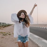 mujer feliz de pie en la carretera