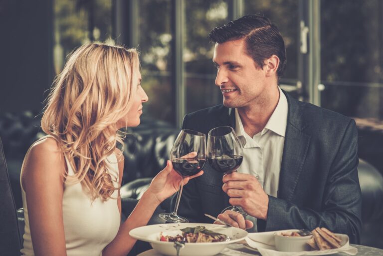 Cheerful couple in a restaurant with glasses of red wine