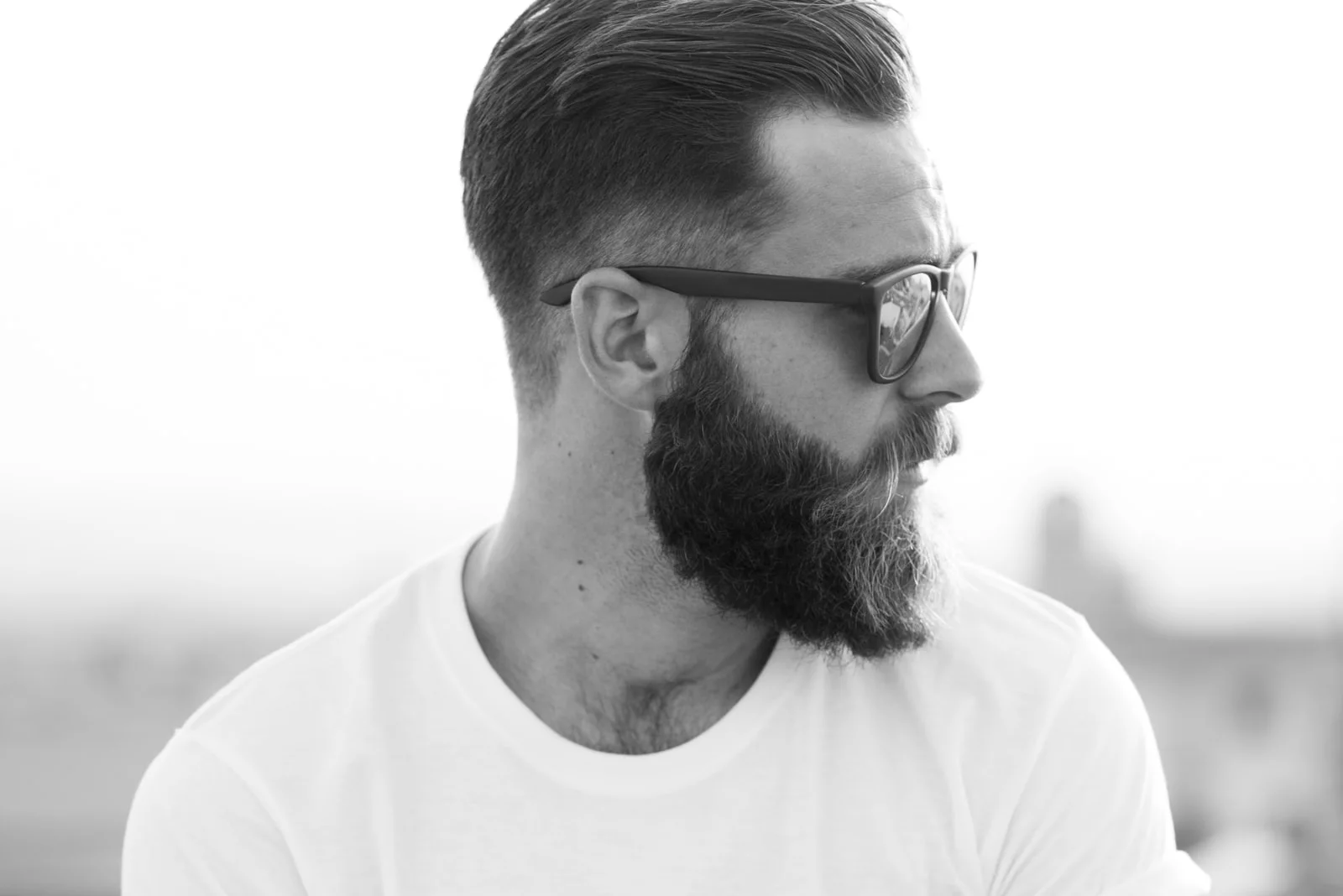 Bearded man posing in the street with sunglasses