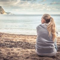 lonely woman sitting on the beach