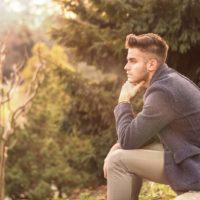 Handsome serious young man outdoors thinking