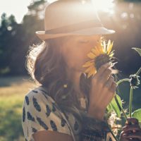 woman smelling sunflower