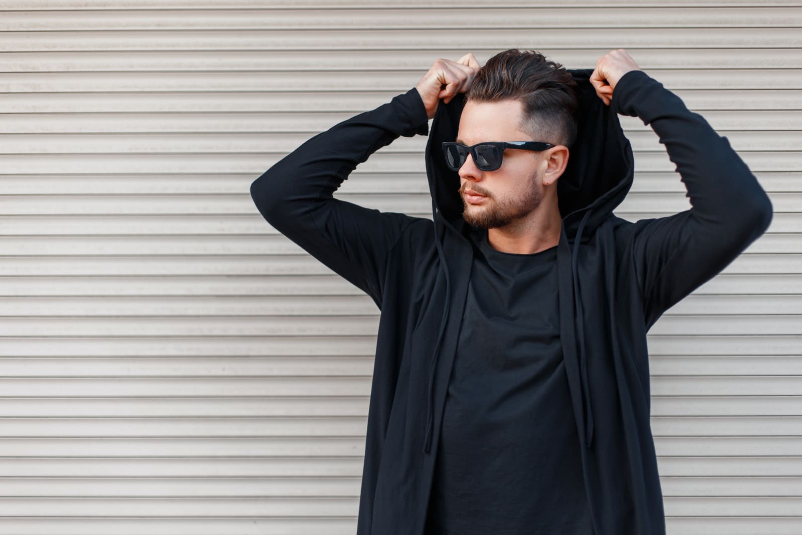 Jovem elegante com barba e óculos de sol