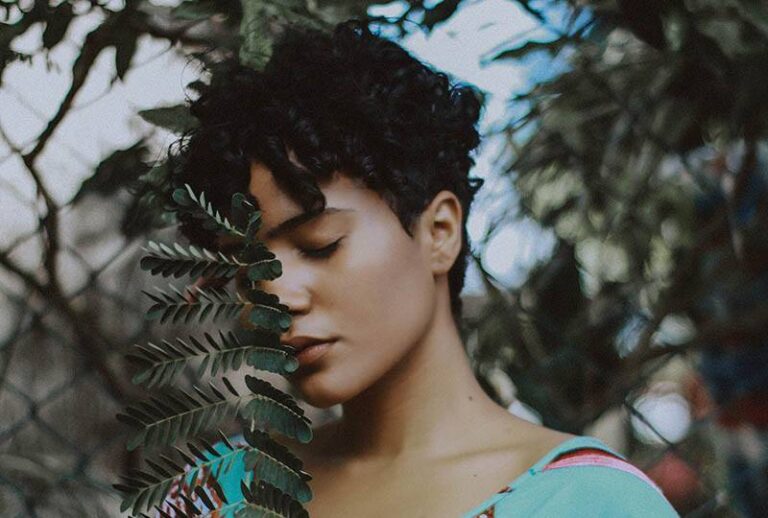 woman with closed eyes holding a leafs