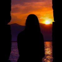 uma rapariga solitária ao pôr do sol