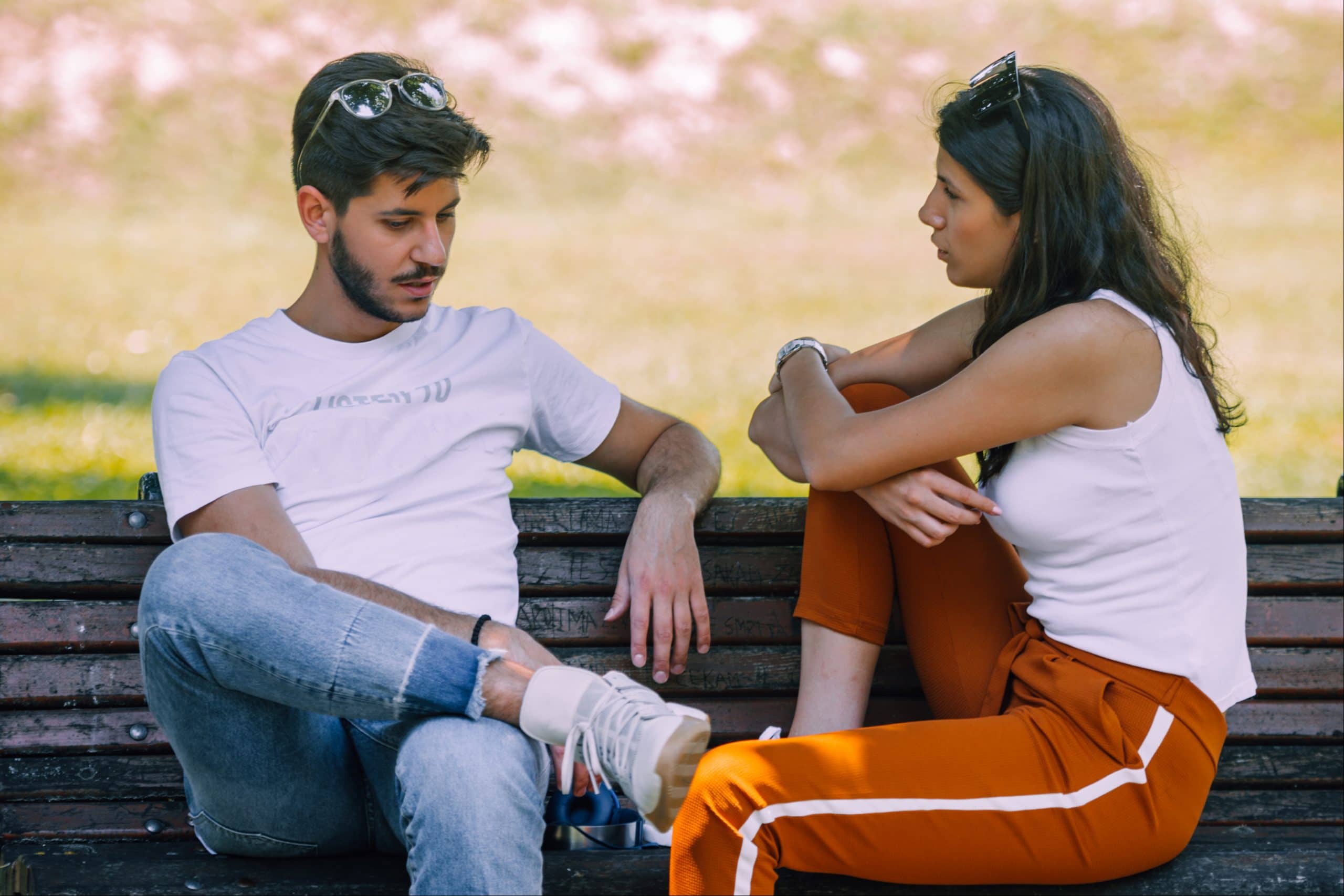 una pareja de enamorados en un banco del parque hablando seriamente