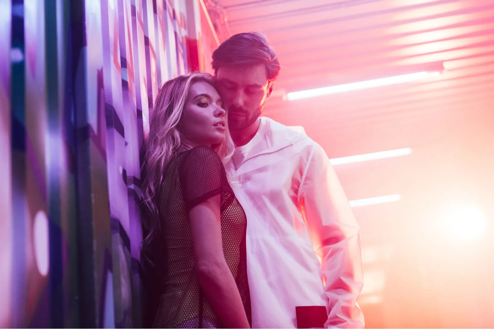 blonde woman hugging with handsome man in night club