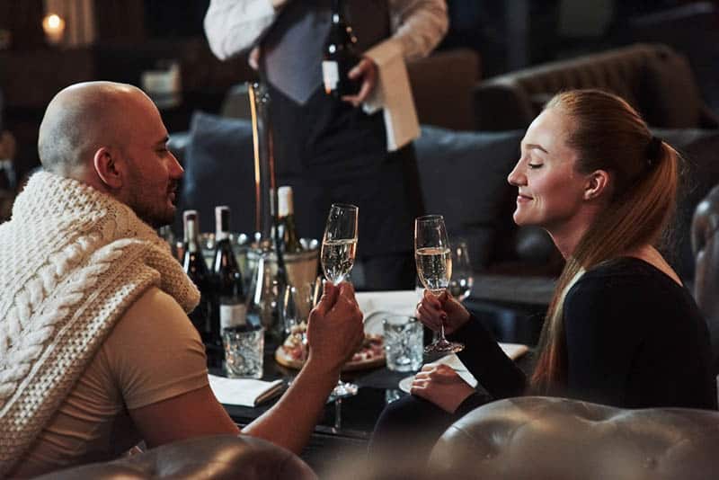 couple holding glass of wine and looking at each other