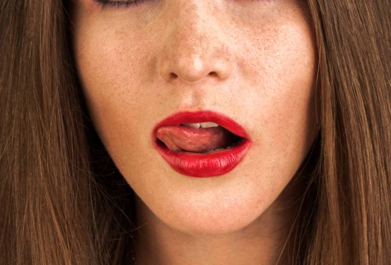 ragazza con rossetto rosso si lecca le labbra